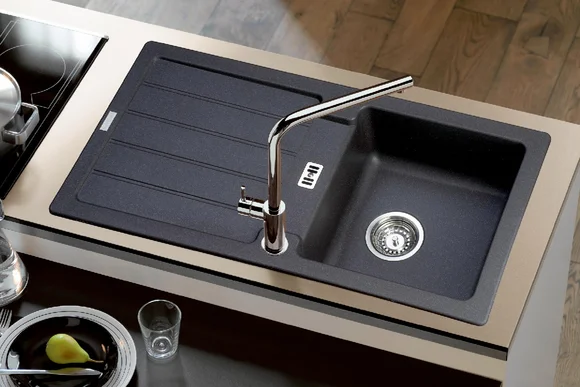 Schwarze Doppelspüle mit Armatur.